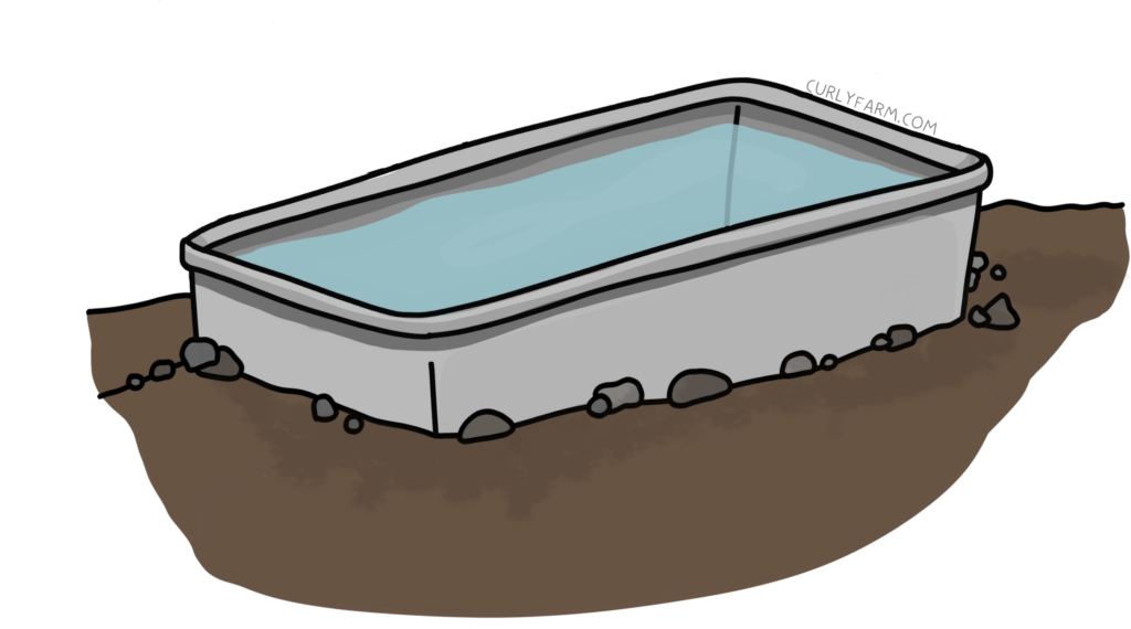 A horse trough shown buried in rocky dirt, as a way to prevent freezing without electricity.